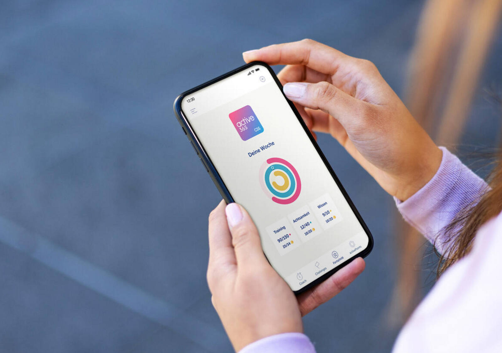 Eine Frau hält ein Handy und betrachtet die active365-App.