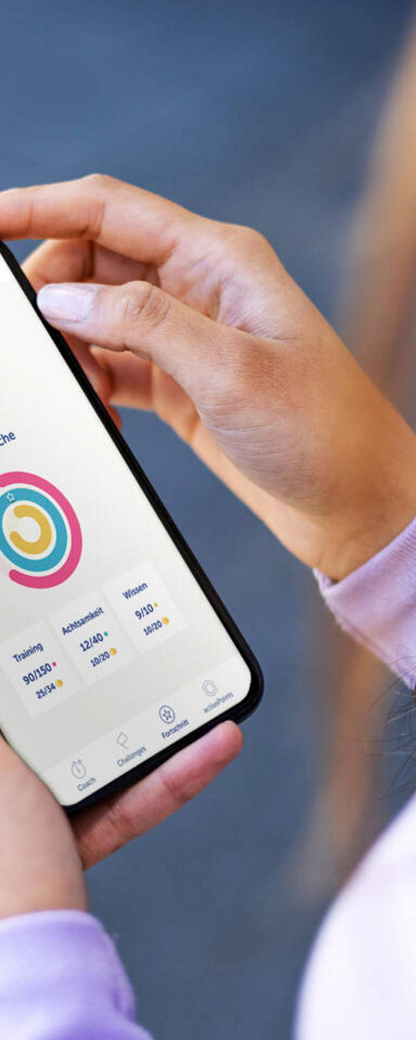 Eine Frau hält ein Handy und betrachtet die active365-App.