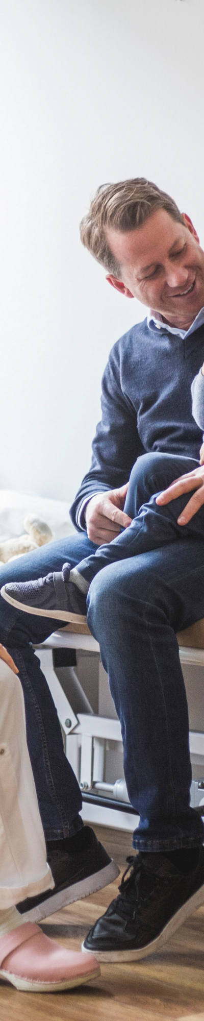 Vater mit Kind bei Ärztin zur Untersuchung