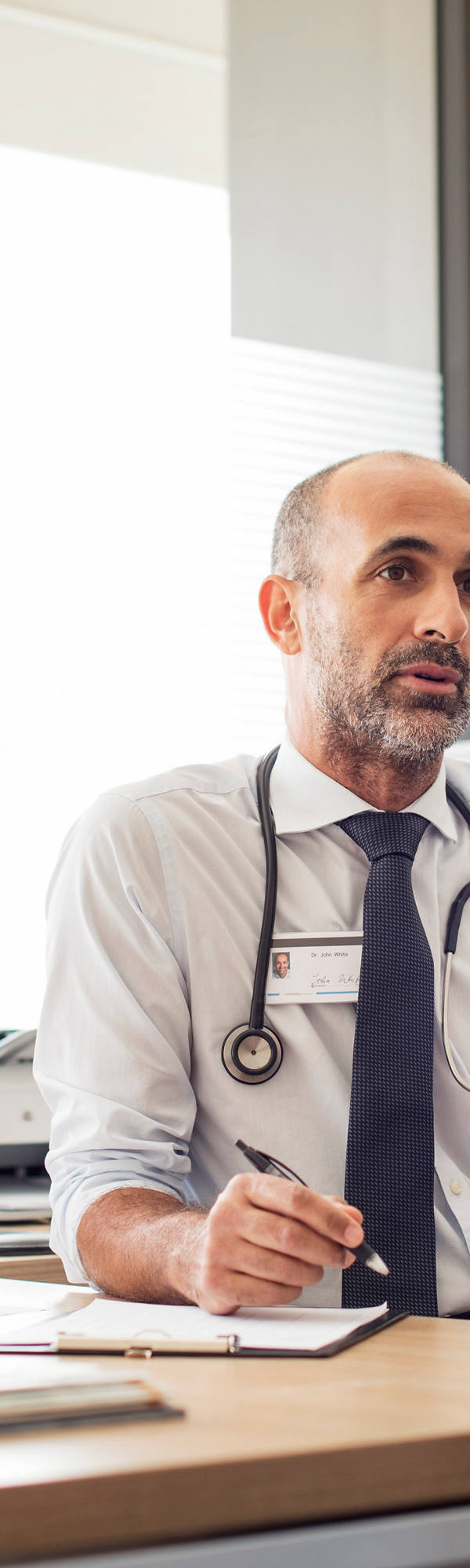 Doctor speaks to patient in doctor’s office.