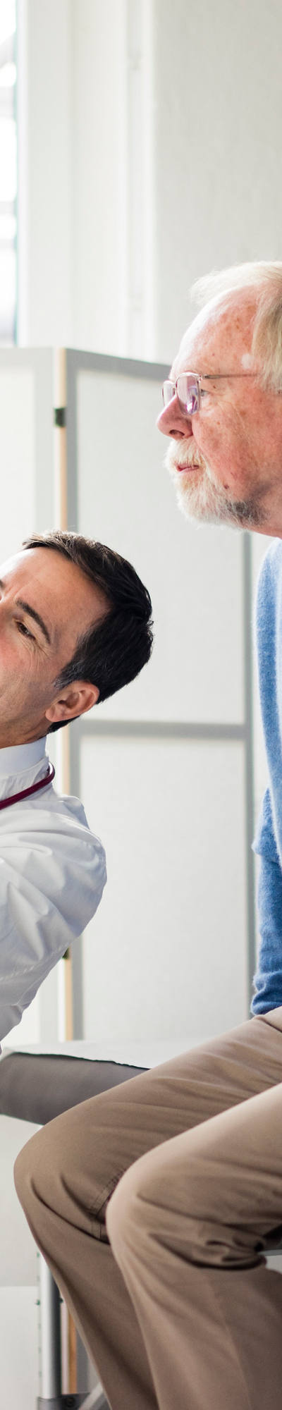 Un medico discute le risonanze magnetiche con il suo paziente anziano nella sala riunioni.