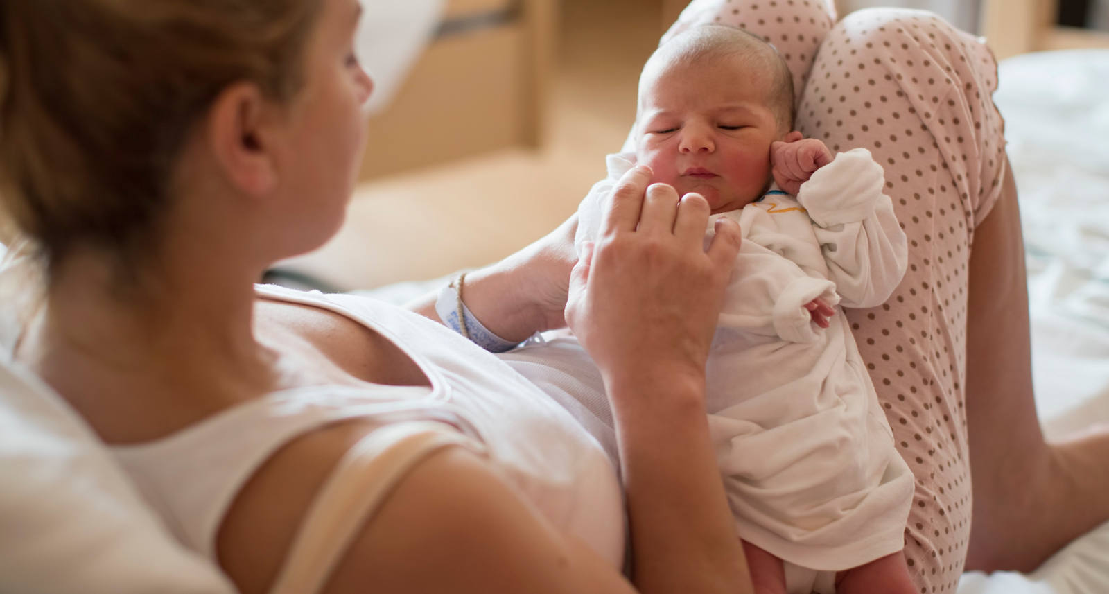 Jeune mère est allongée au lit avec son nouveau-né