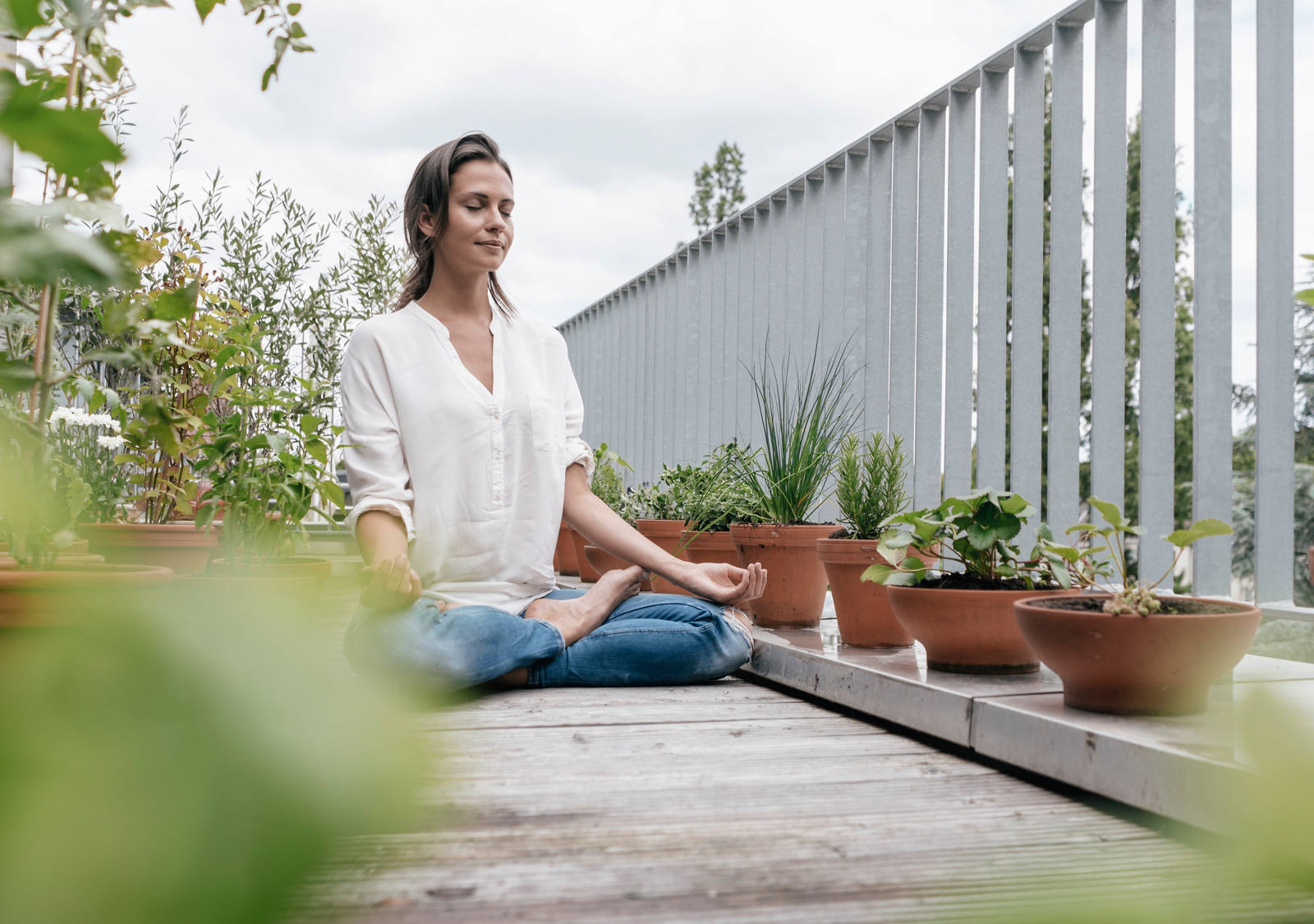 Woman meditating in cross-legged position on the balcony