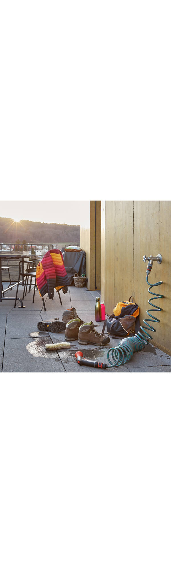 Pulizia delle scarpe da escursione sul balcone