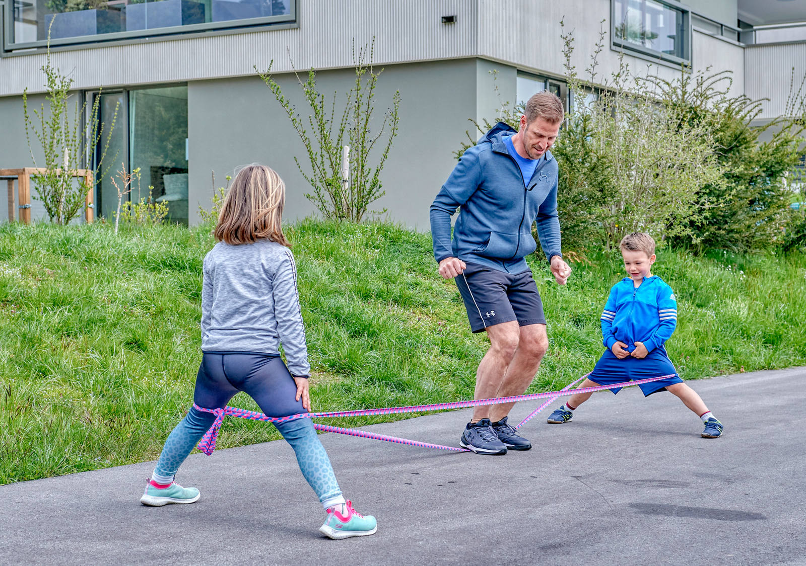 Father plays with children with elastic twist