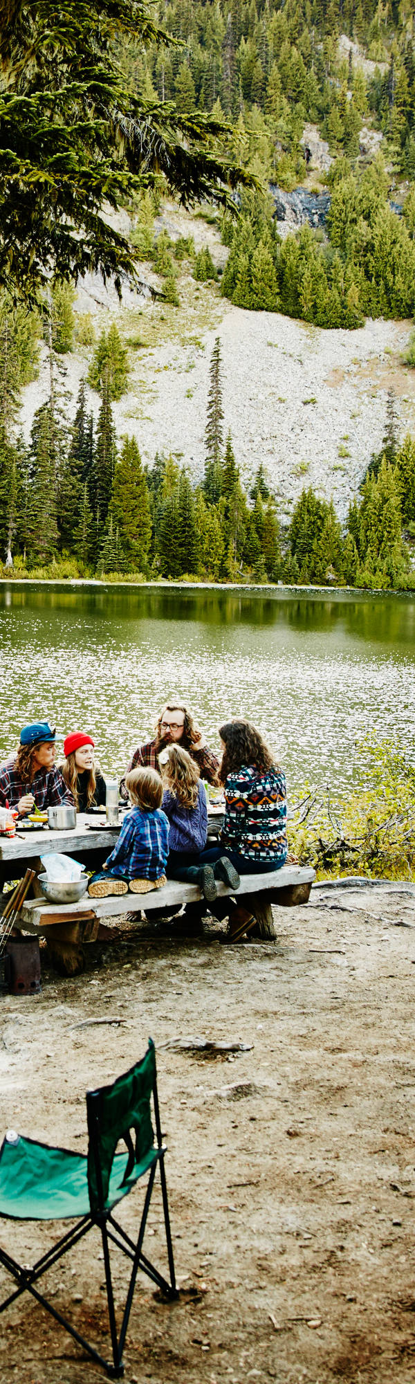 Une famille campant à l’état sauvage dans une forêt avec lac