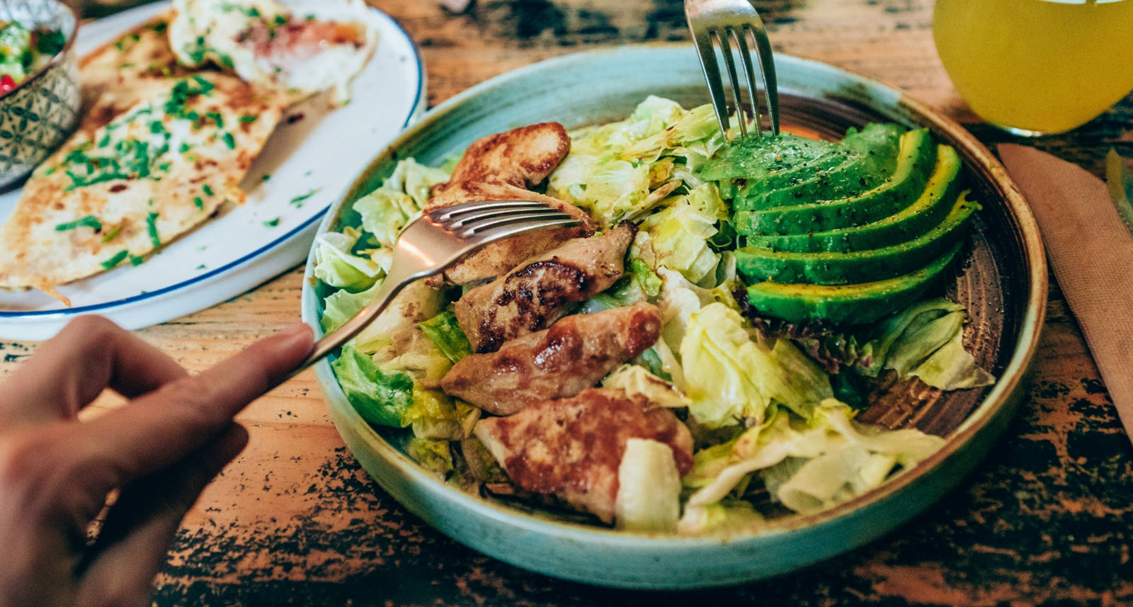 Menschen essen aus einer Bowl auf einem Tisch.
