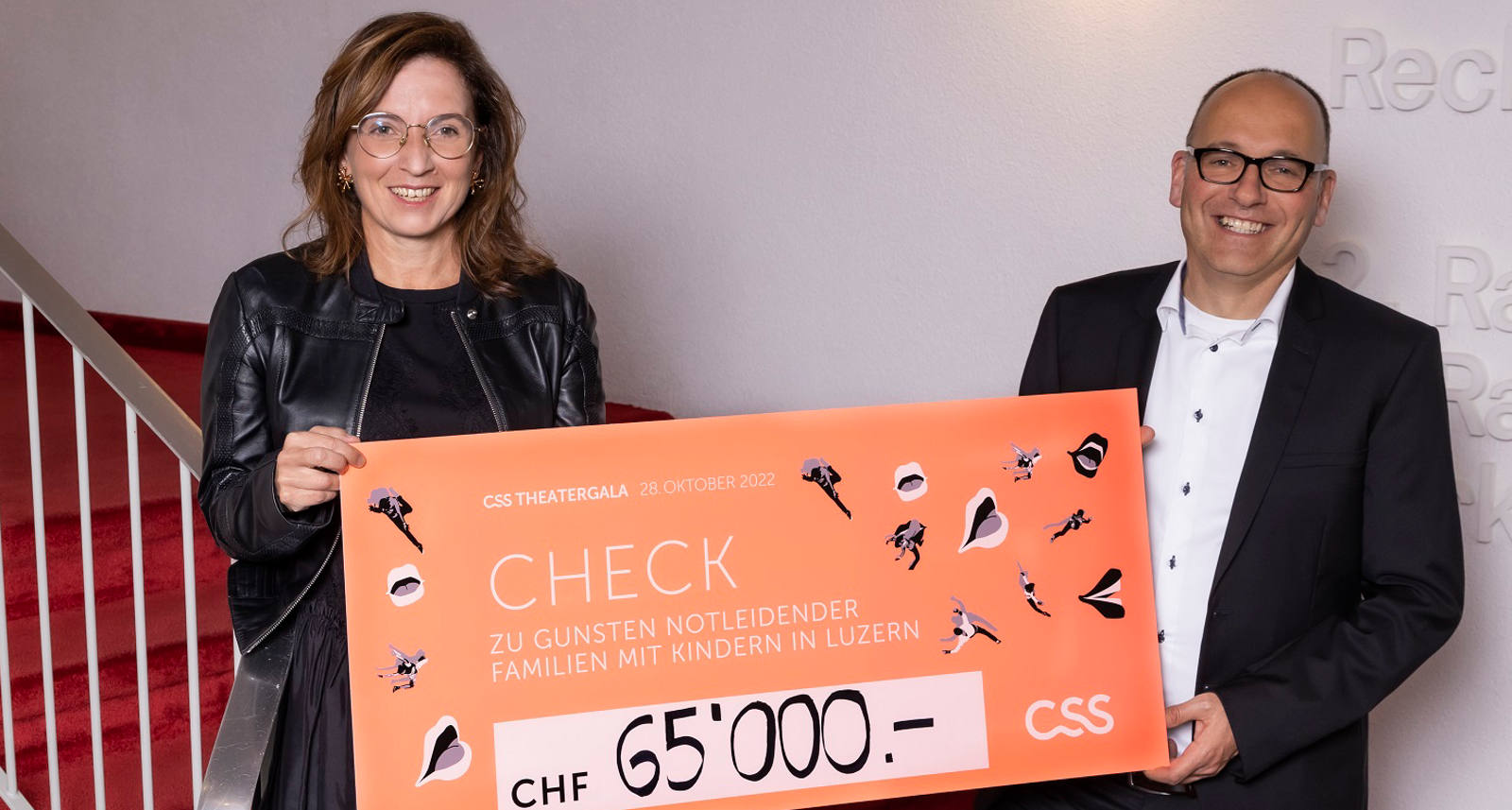 Philomena Colatrella, CEO der CSS, überreicht den Check im Theater Luzern an Daniel Furrer, Geschäftsleiter Caritas Luzern
