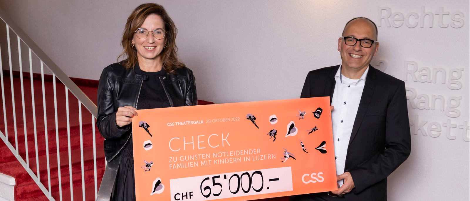Philomena Colatrella, CEO der CSS, überreicht den Check im Theater Luzern an Daniel Furrer, Geschäftsleiter Caritas Luzern