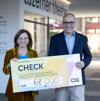 Philomena Colatrella, CEO der CSS, überreicht den Check im Theater Luzern an Daniel Furrer, Geschäftsleiter der Caritas Luzern