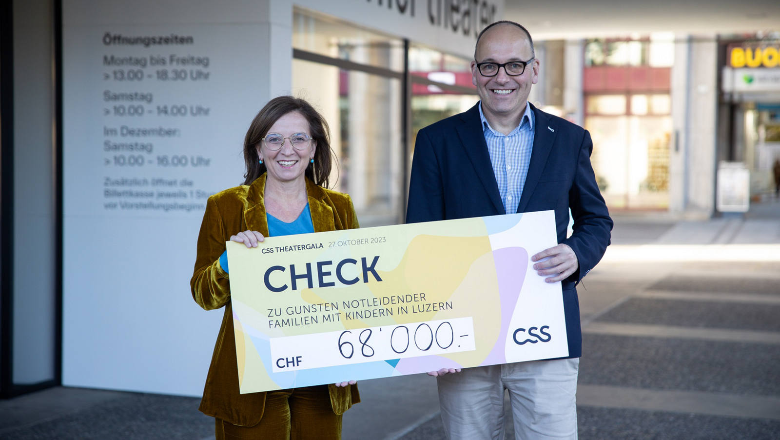 Philomena Colatrella, CEO der CSS, überreicht den Check im Theater Luzern an Daniel Furrer, Geschäftsleiter der Caritas Luzern