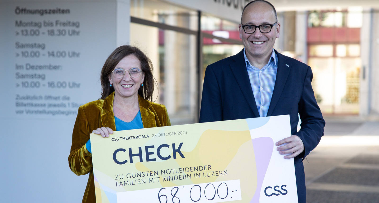 Philomena Colatrella, CEO der CSS, überreicht den Check im Theater Luzern an Daniel Furrer, Geschäftsleiter der Caritas Luzern