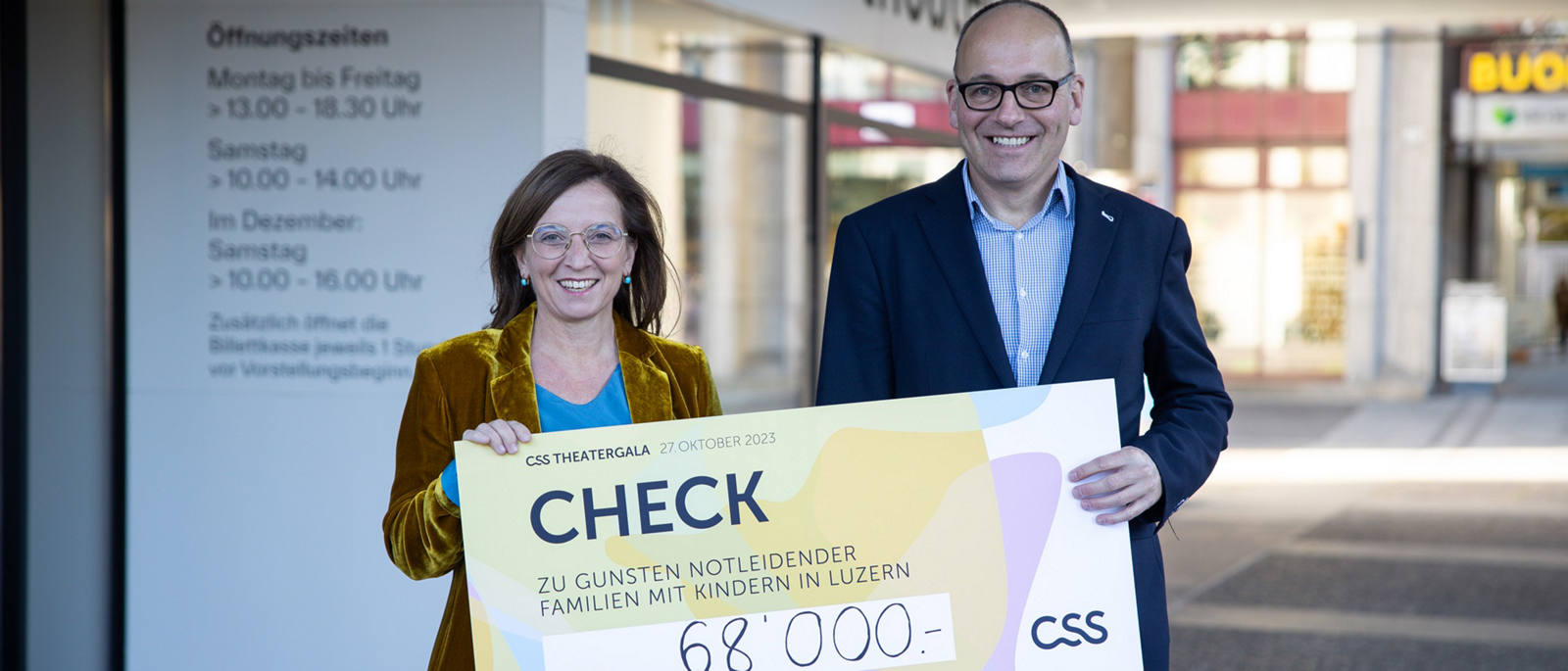 Philomena Colatrella, CEO der CSS, überreicht den Check im Theater Luzern an Daniel Furrer, Geschäftsleiter der Caritas Luzern