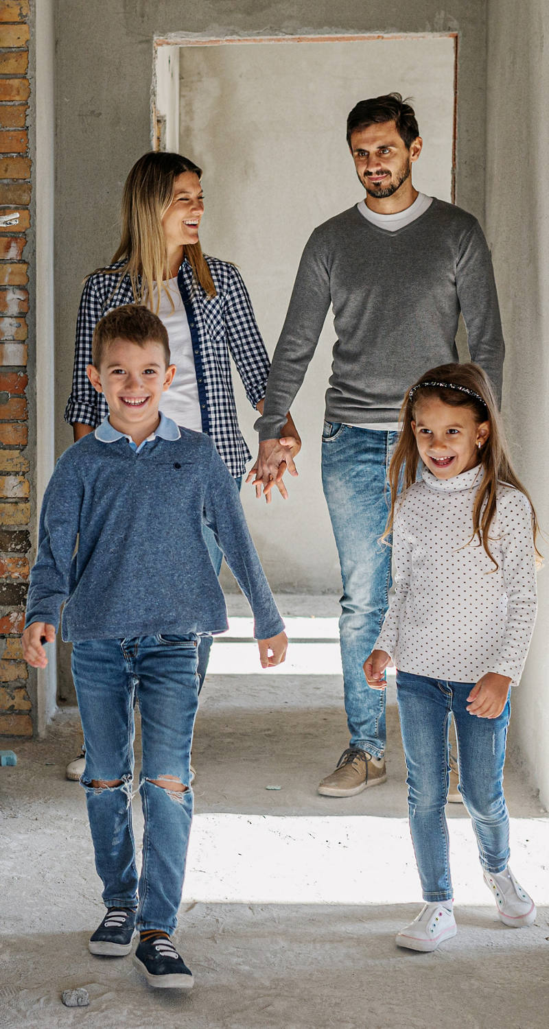 Giovane famiglia nella costruzione grezza della sua nuova casa.