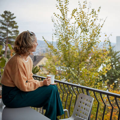 Frau relaxt auf ihrem Balkon