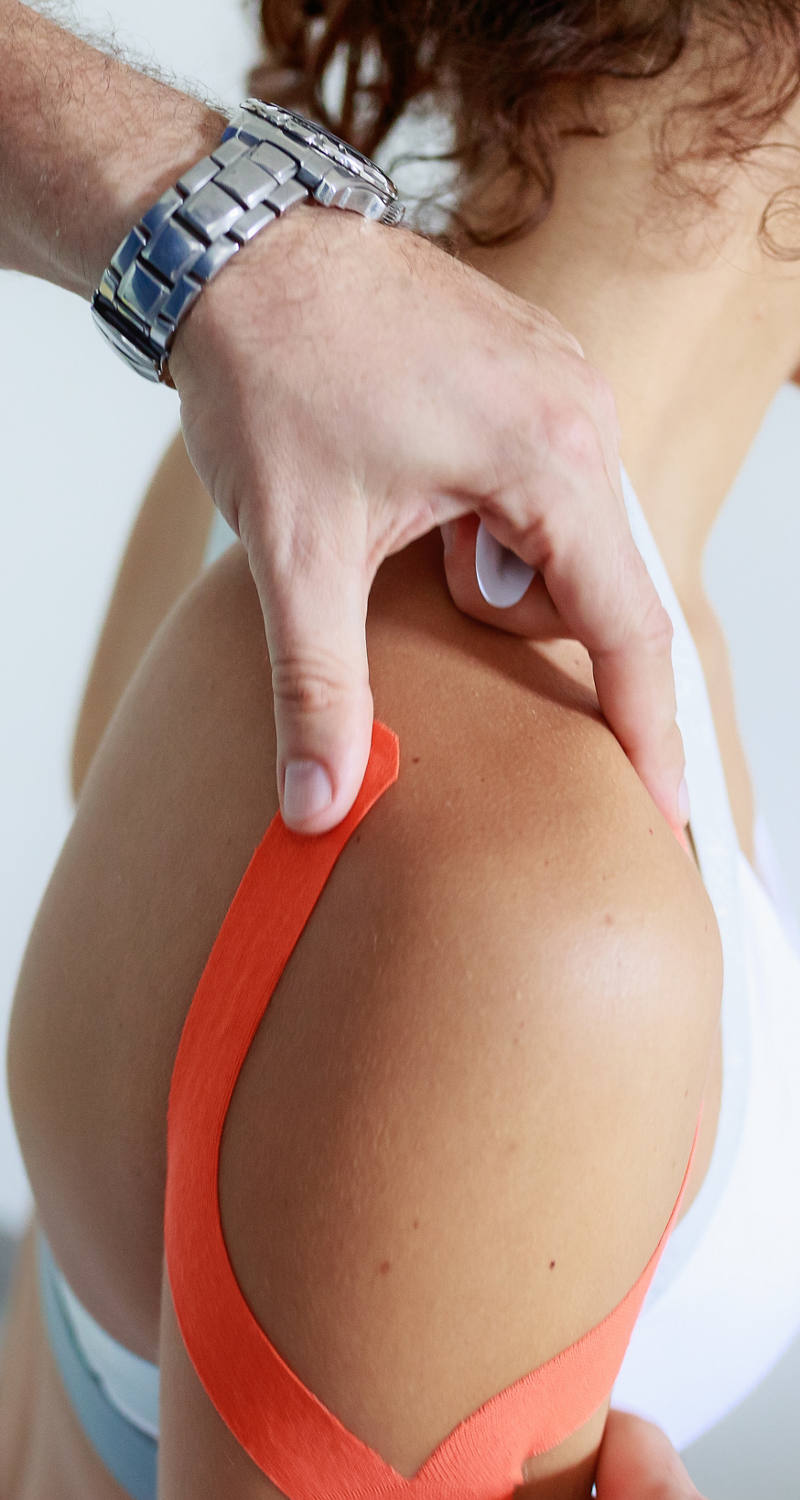  A woman has duct tape on her shoulder and receives kinesiological treatment
