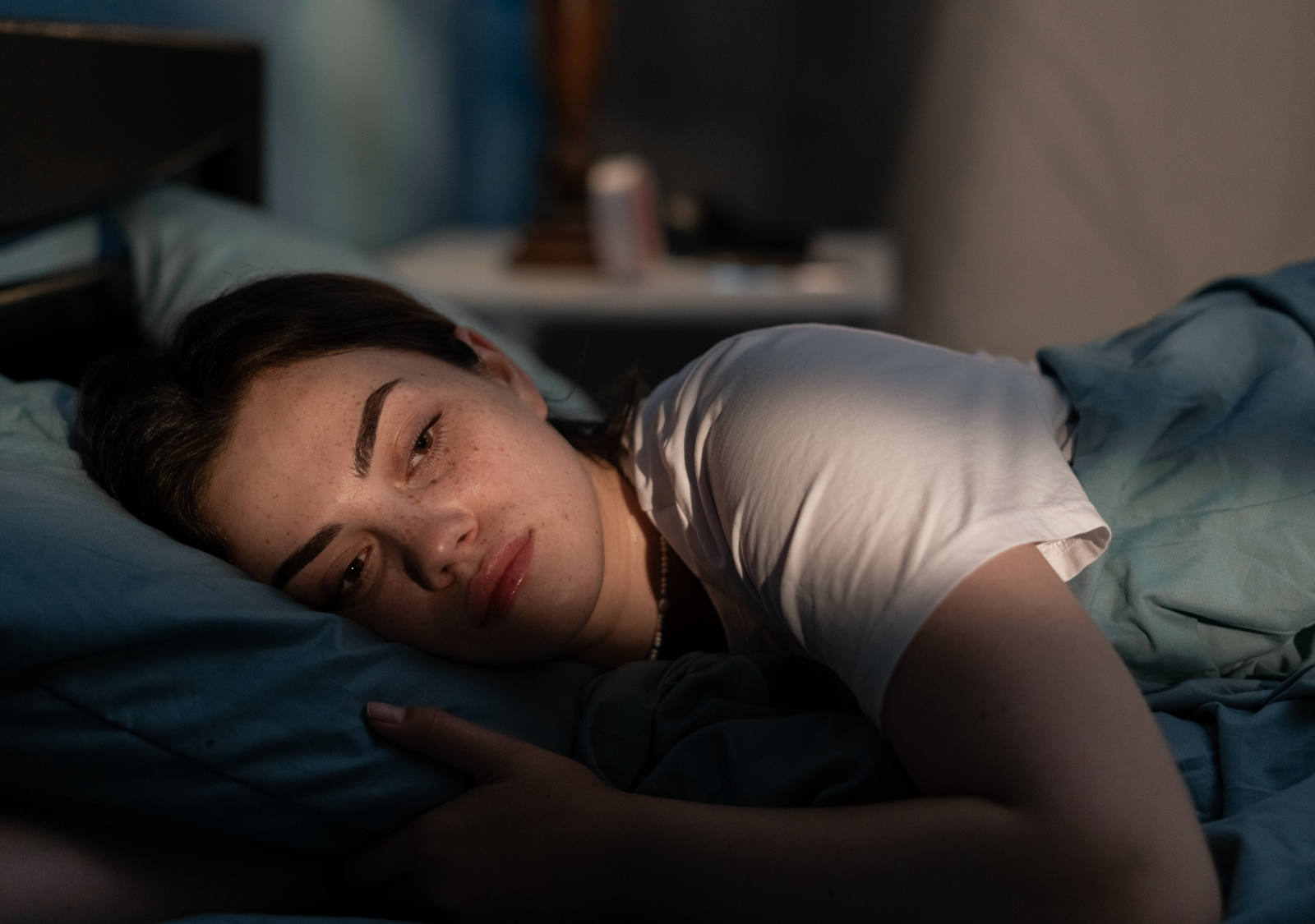 Eine Frau liegt müde im Bett und findet ihren Schlaf nicht.