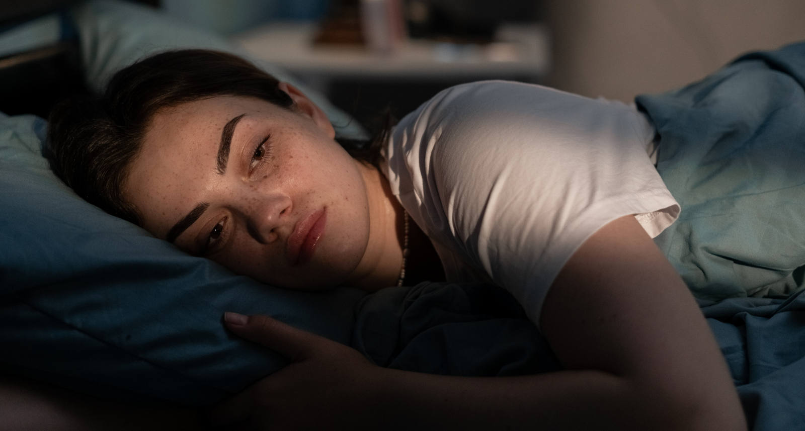 Eine Frau liegt müde im Bett und findet ihren Schlaf nicht.