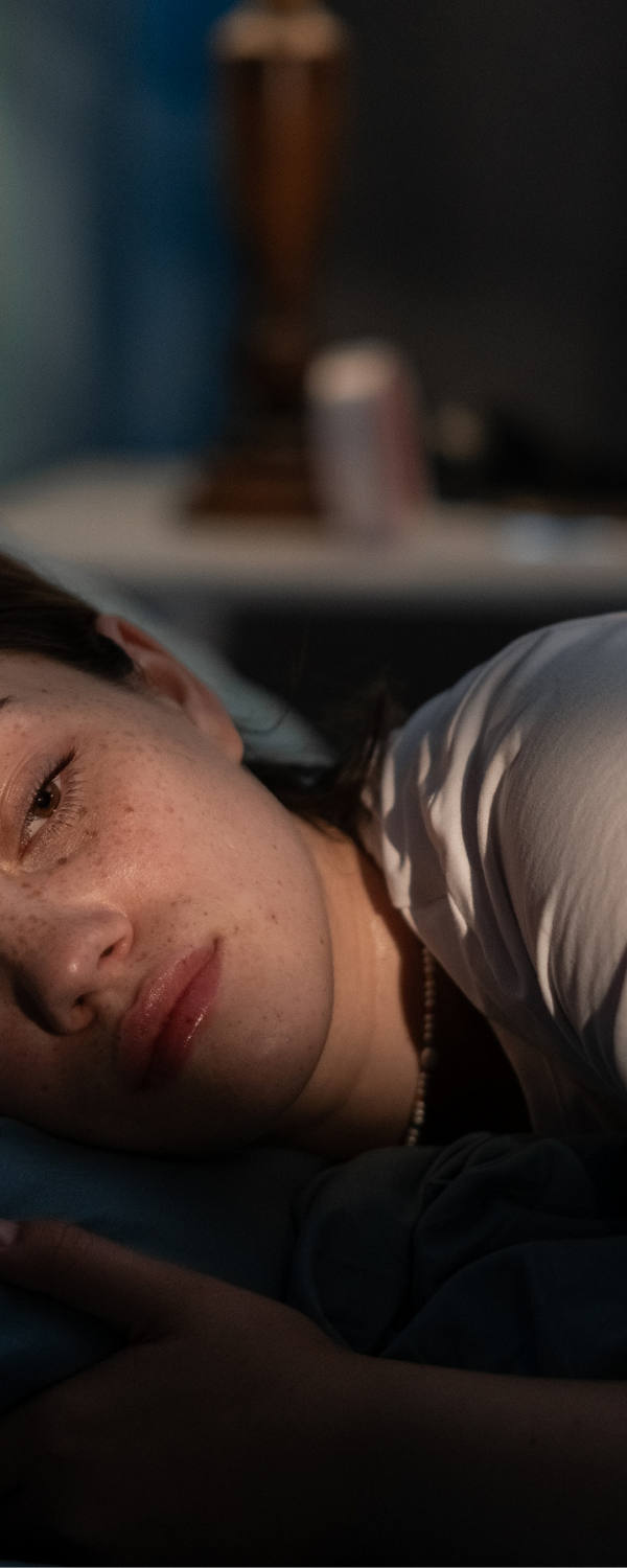 Eine Frau liegt müde im Bett und findet ihren Schlaf nicht.