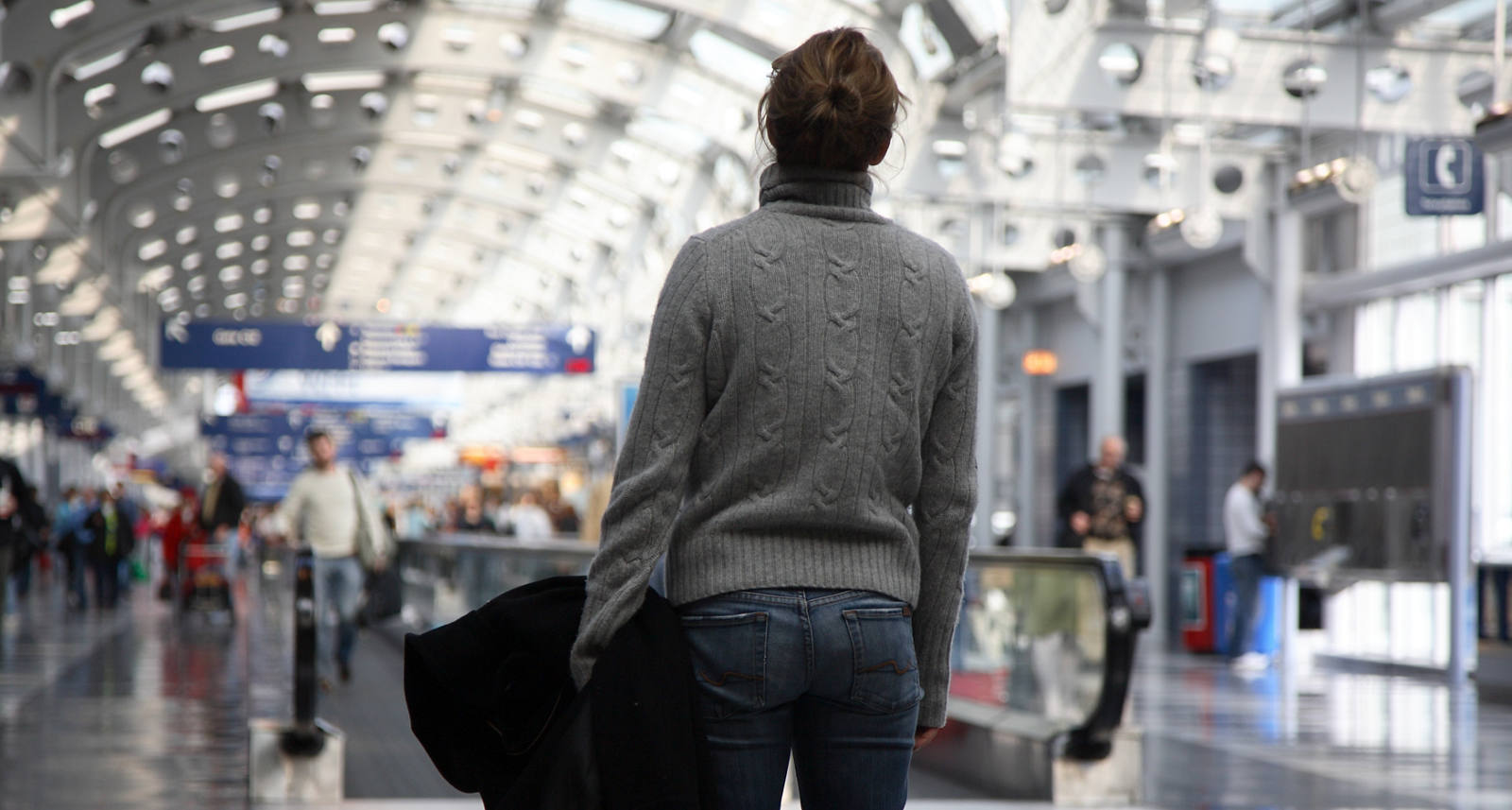 Une femme se trouve dans la foule à l’aéroport, une situation particulièrement stressante pour elle.