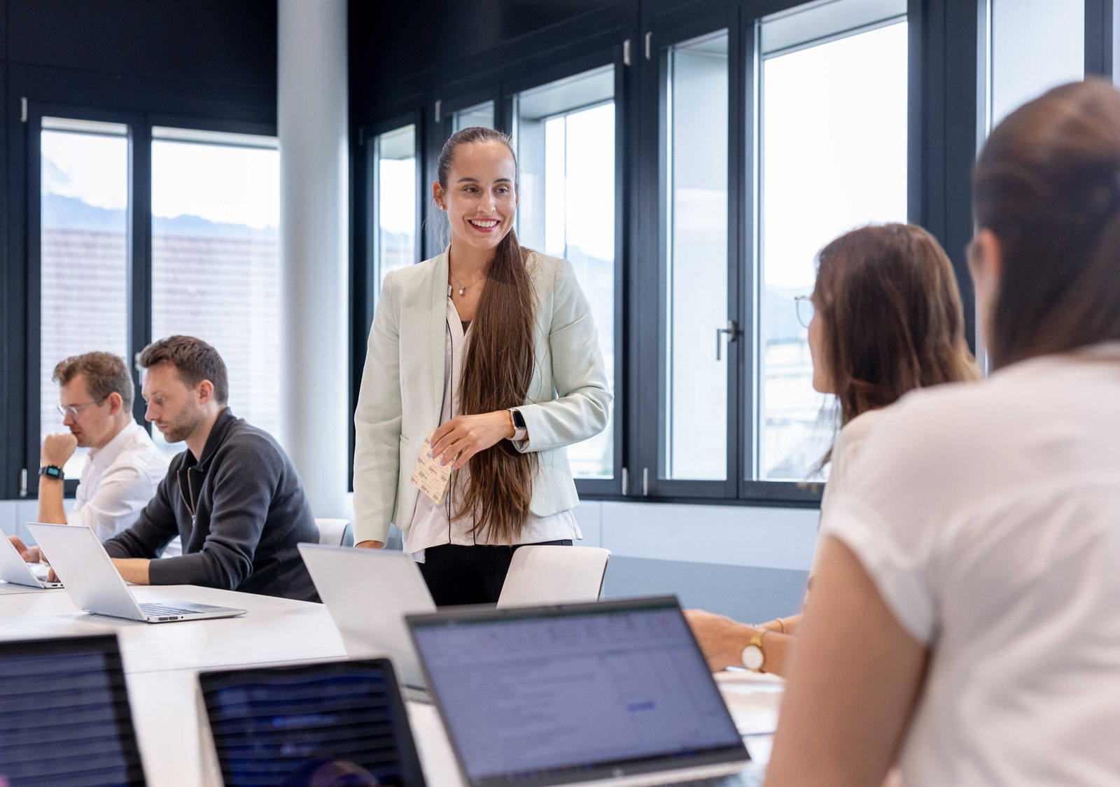A group of employees work together in a meeting room.
