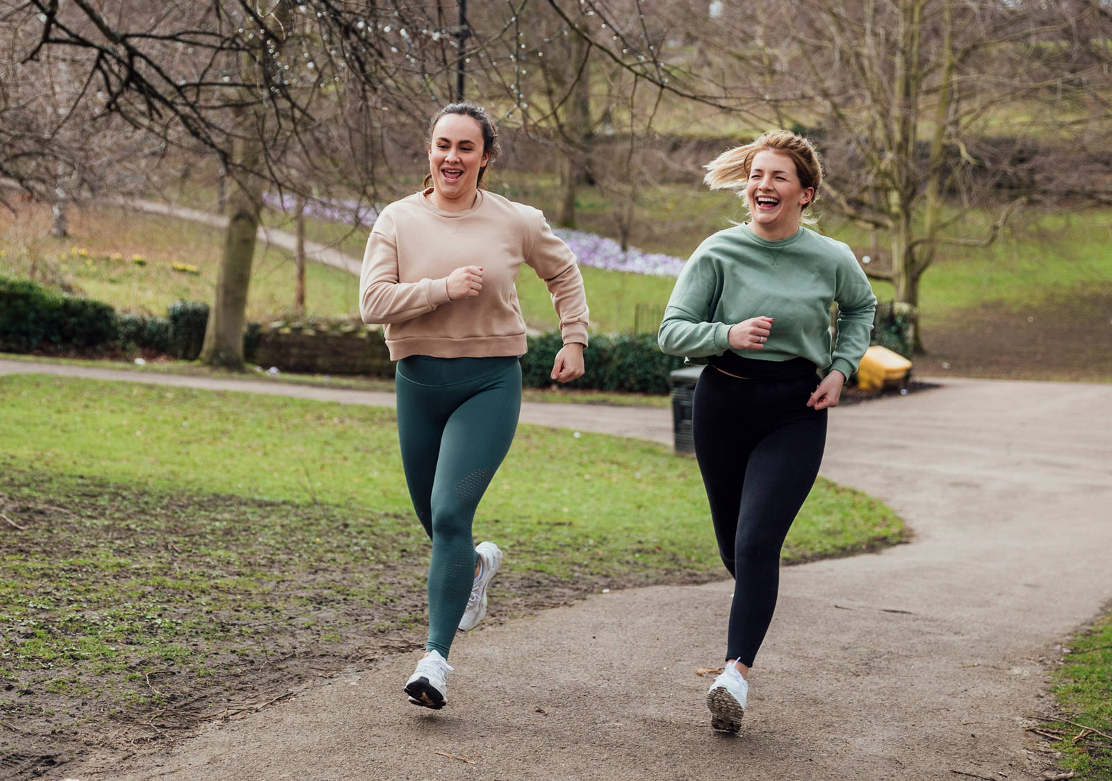 Two women jog in a good mood in the park.
