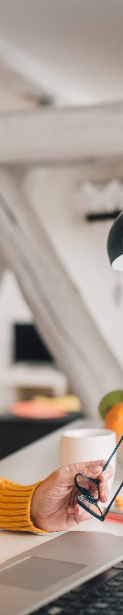 Senior woman working with headphones on her laptop.