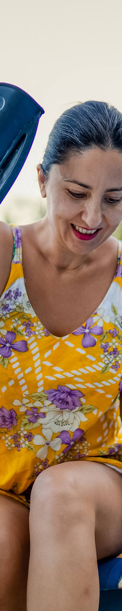 A woman in a swimsuit tries to get up from the sunbed and clings to her crutches.