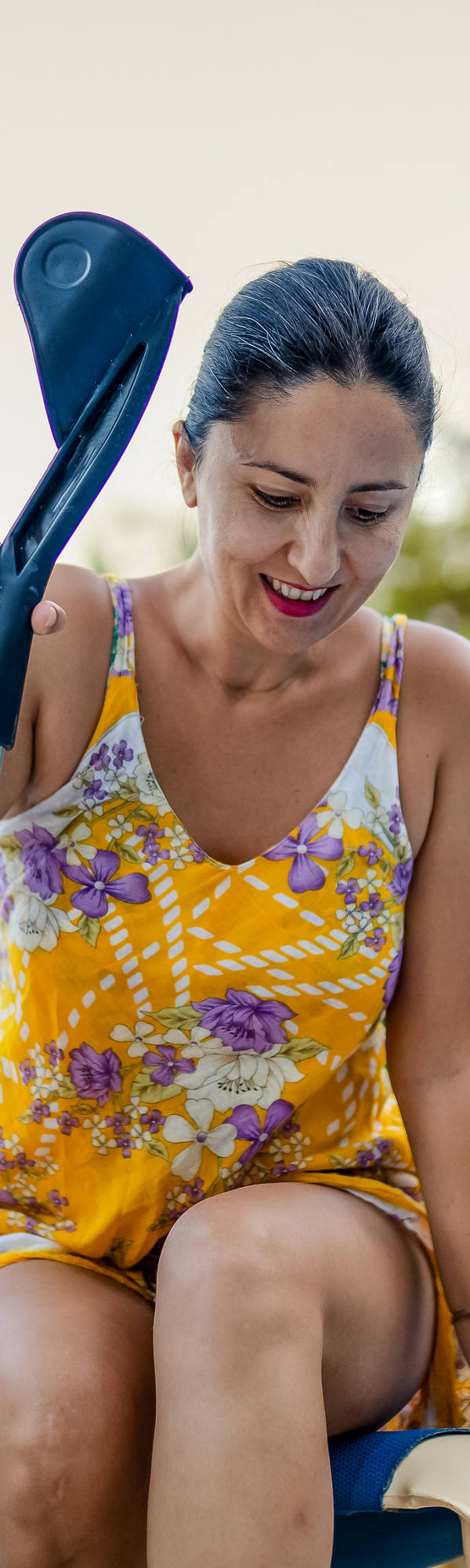 A woman in a swimsuit tries to get up from the sunbed and clings to her crutches.