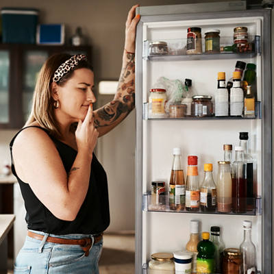 Frau prüft den Inhalt ihres Kühlschranks