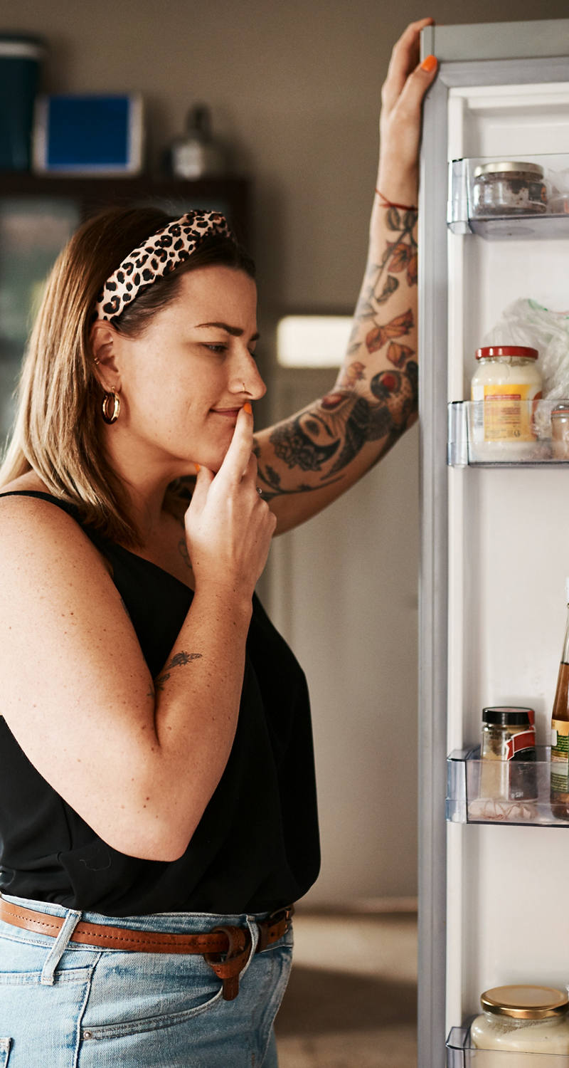 Frau prüft den Inhalt ihres Kühlschranks