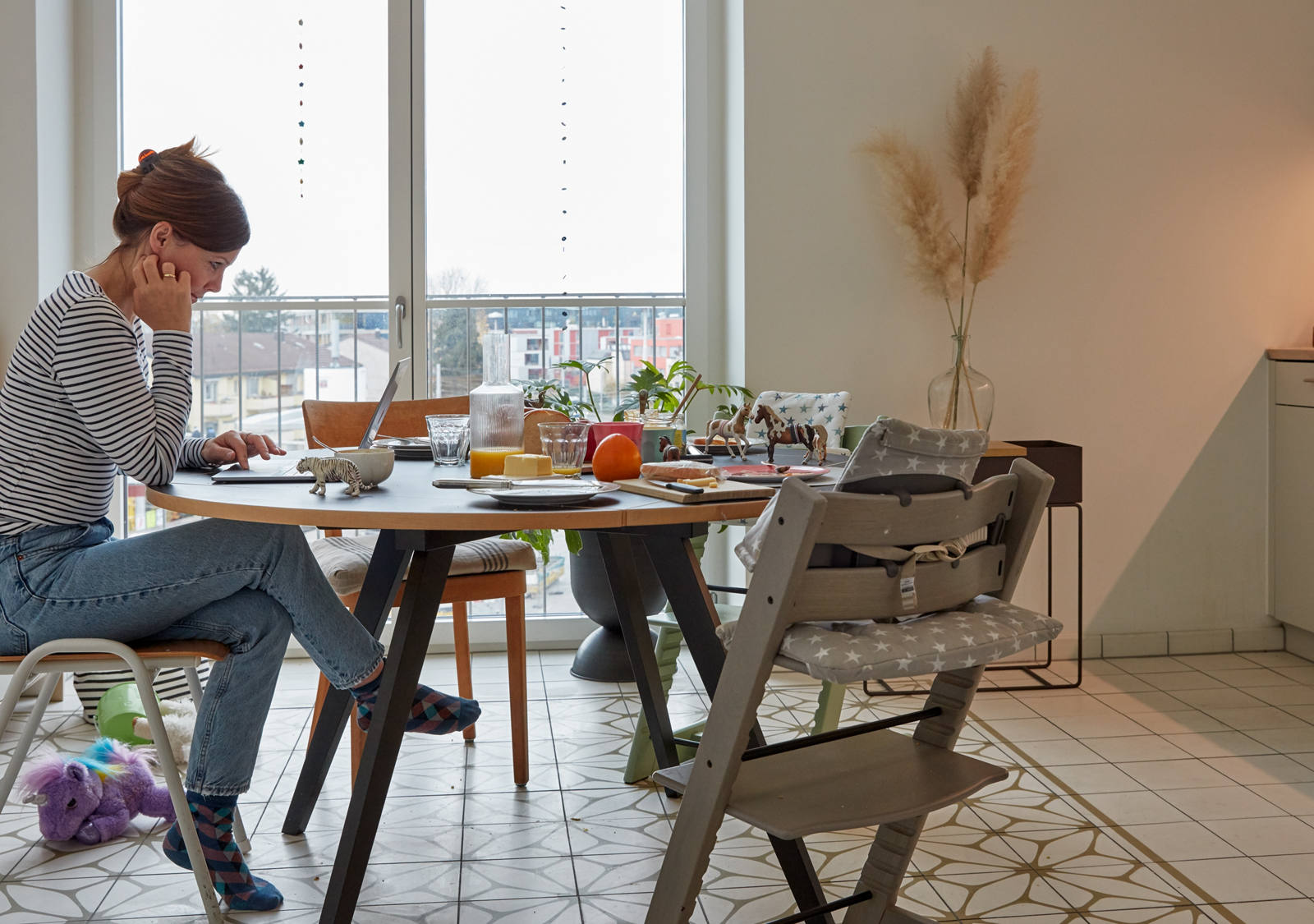 Frau sitzt mit Laptop am Esstisch