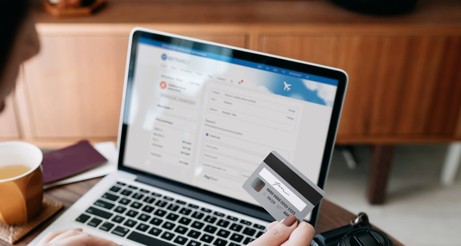 Frau sitzt am Laptop und macht eine Zahlung mit Ihrer Kreditkarte