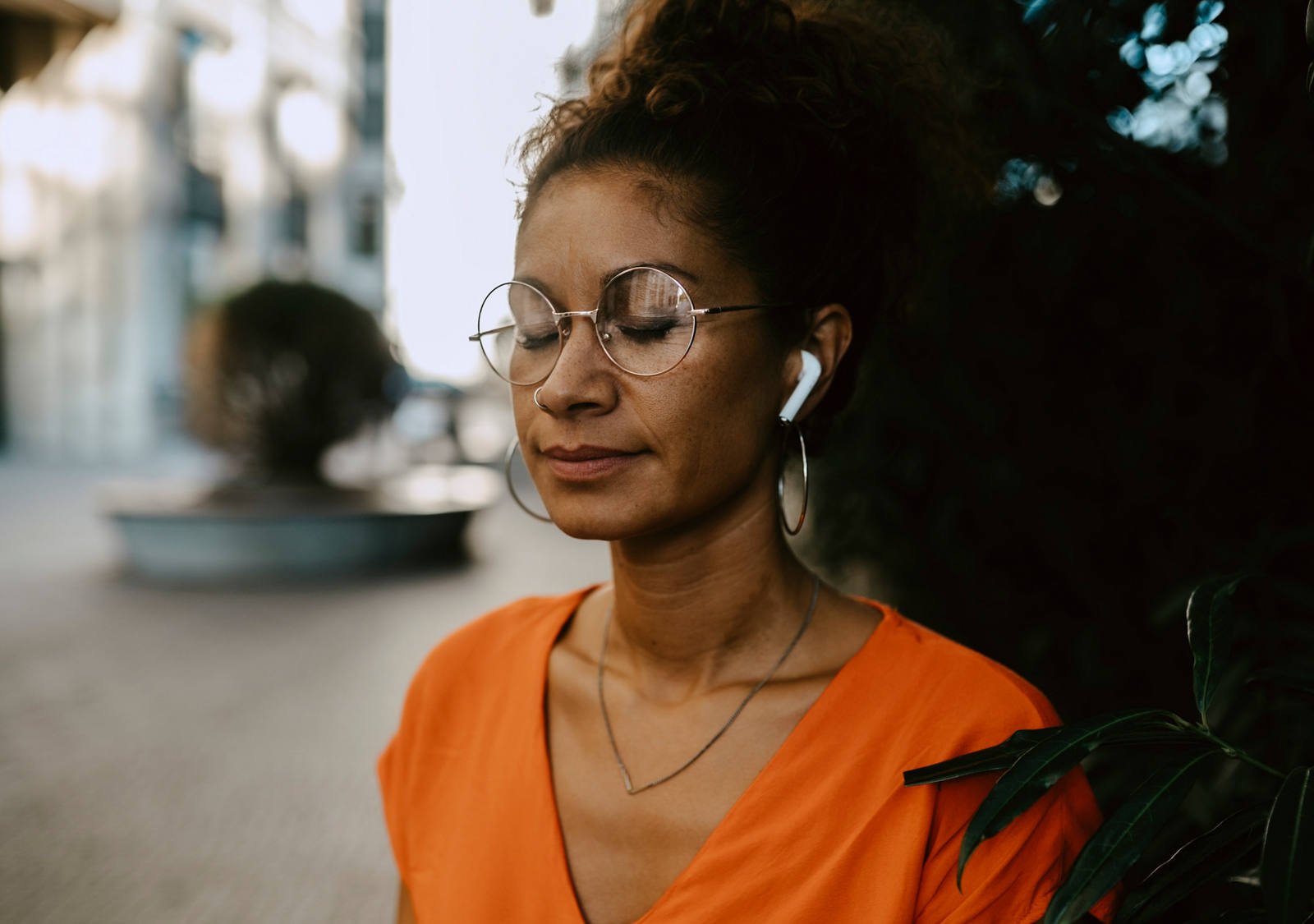 Woman meditating with closed eyes and headphones in ears