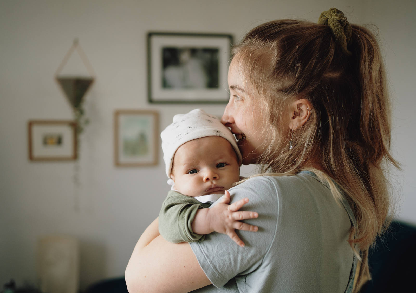 Eine junge Frau hält ihr Baby innig im Arm.