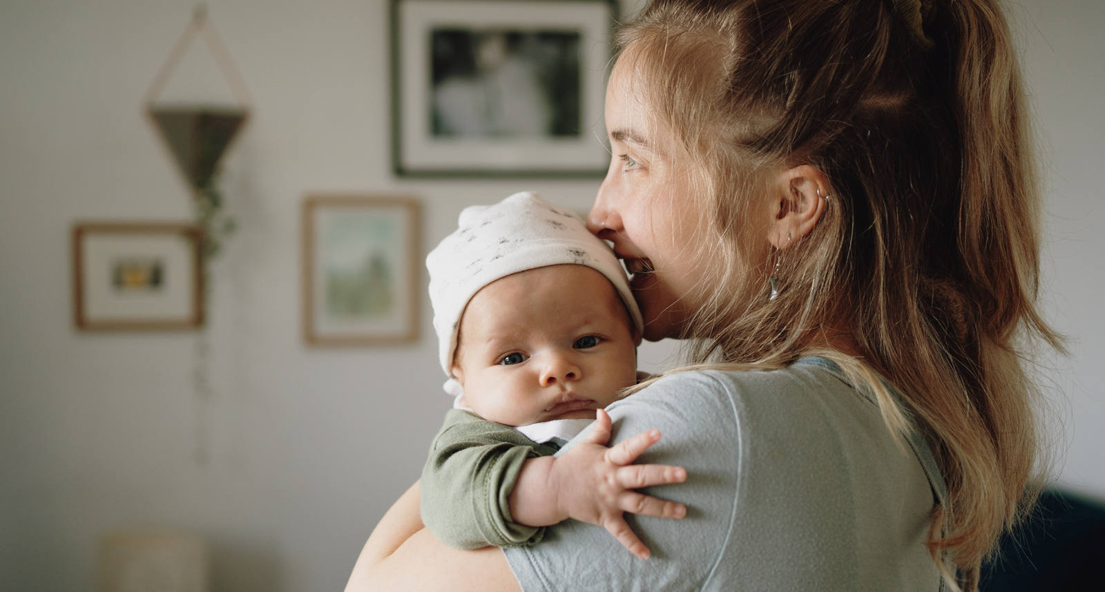 Eine junge Frau hält ihr Baby innig im Arm.