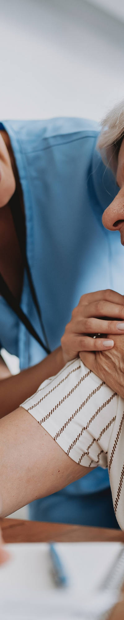 Doctor gives support to older patient.