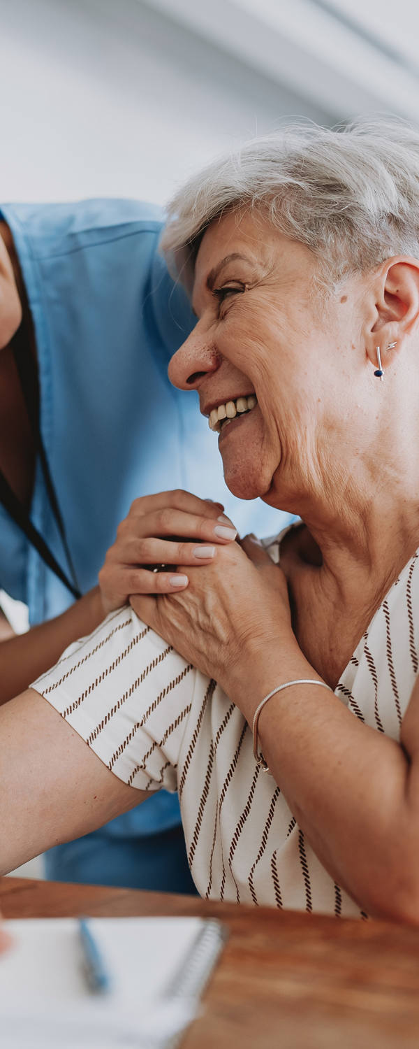 Doctor gives support to older patient.