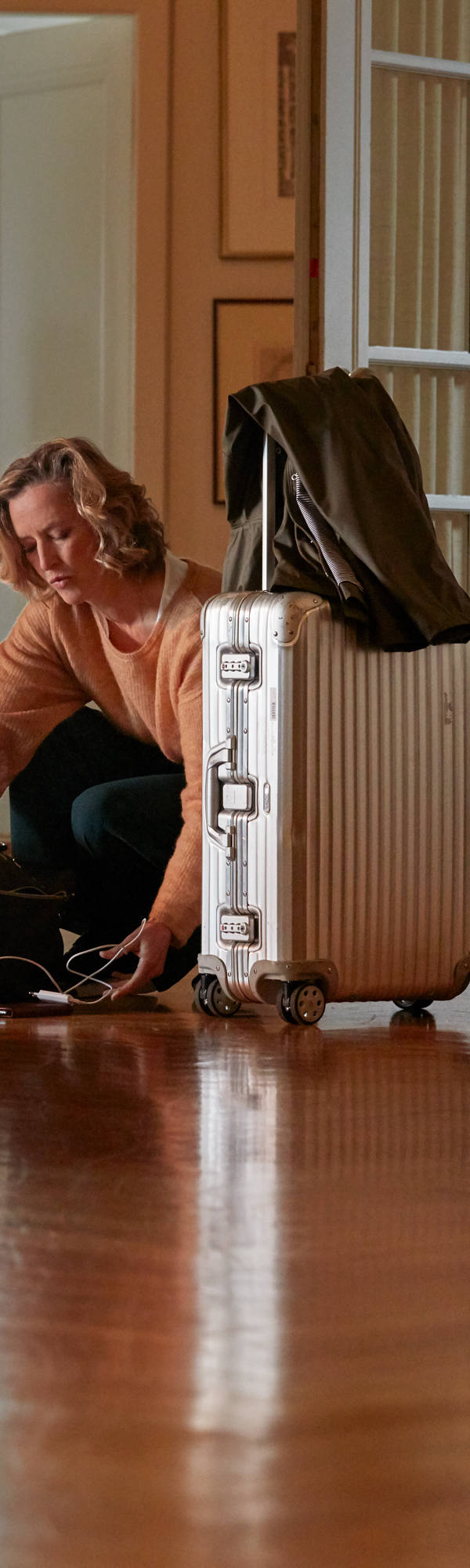 Femme fait des valises dans le couloir de son appartement