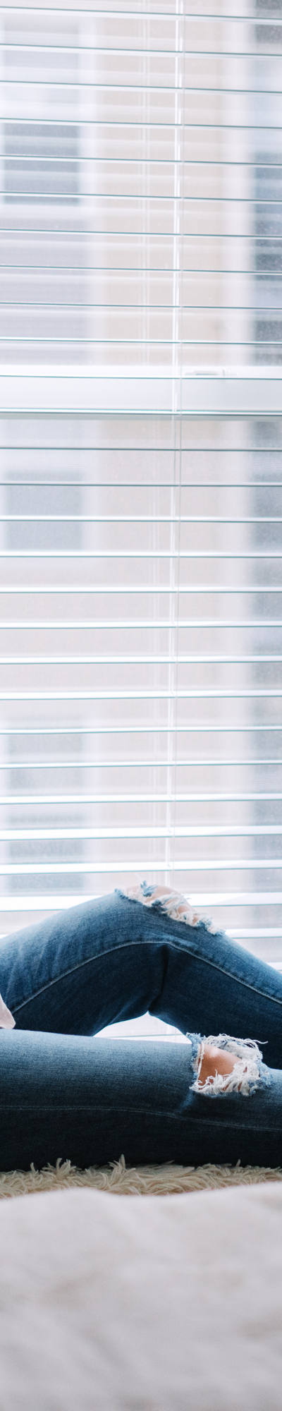 Donna incinta beve tè sul davanzale della finestra e scrolla sullo smartphone