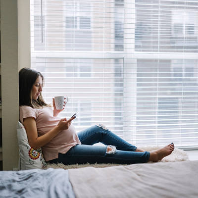 Schwangere Frau am Smartphone