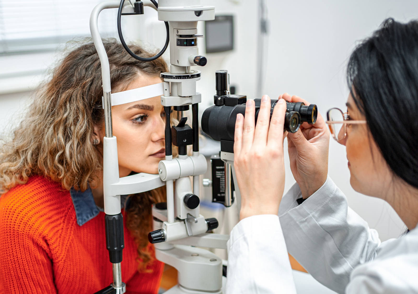 Augenärztin untersucht die Augen einer jungen Patientin