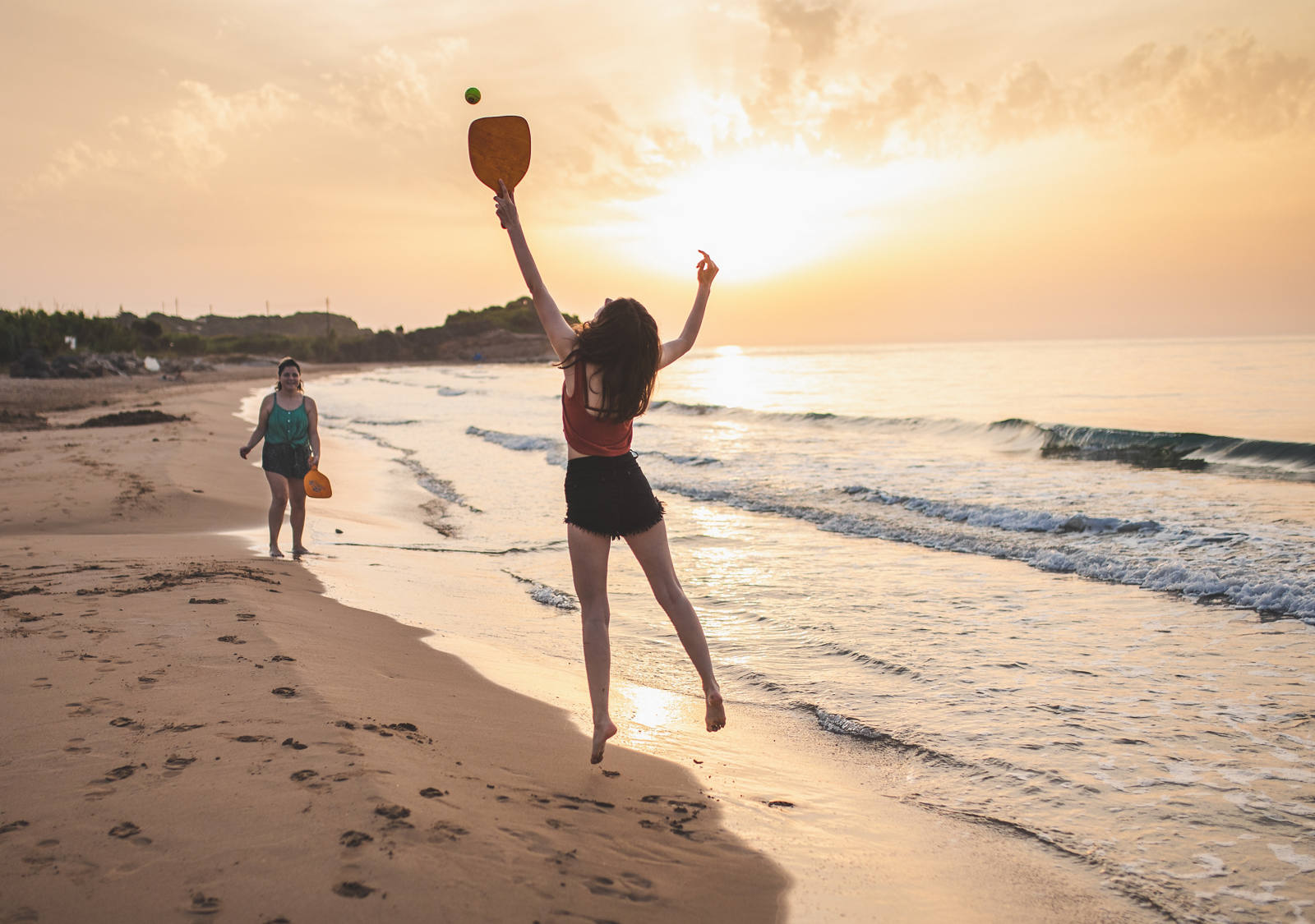 Zwei Frauen spielen am Strand Beachball.