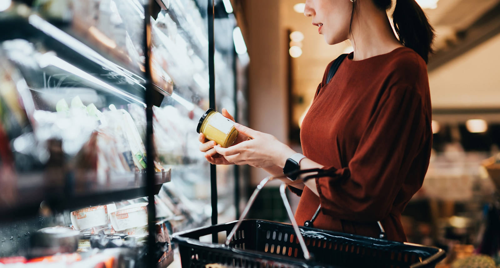 Woman examines ingredients of a product in supermarket