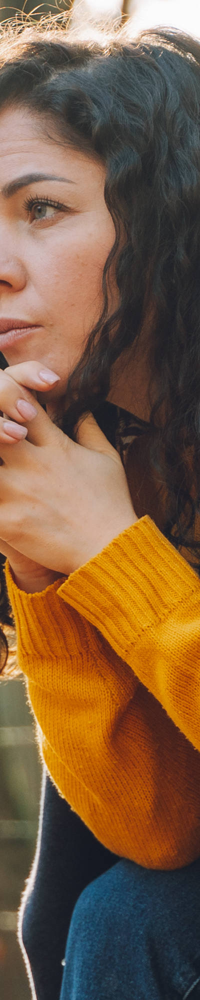  A woman sits sadly on a bench in the park.