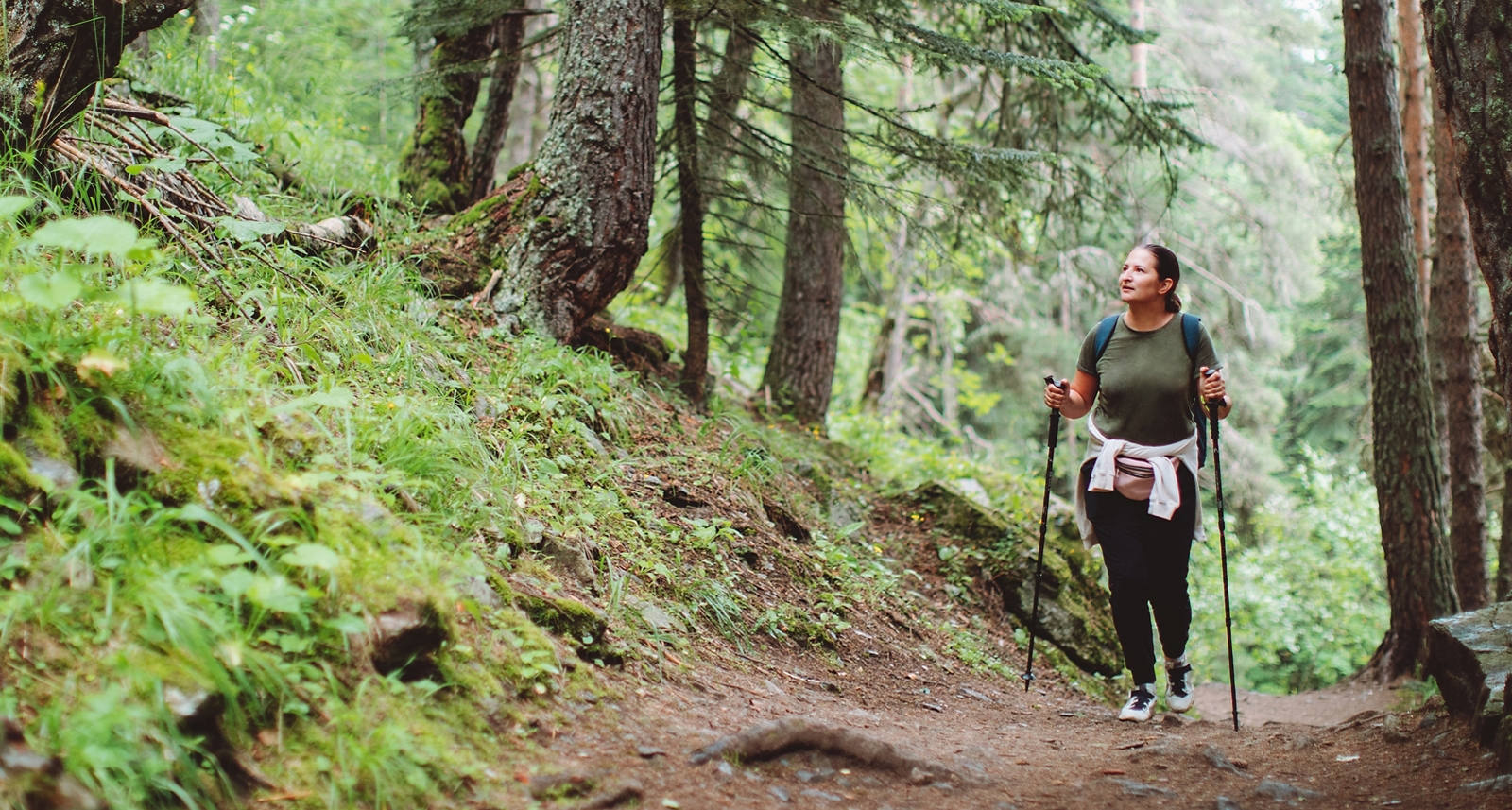 Frau geht an Stöcken in im Wald wandern