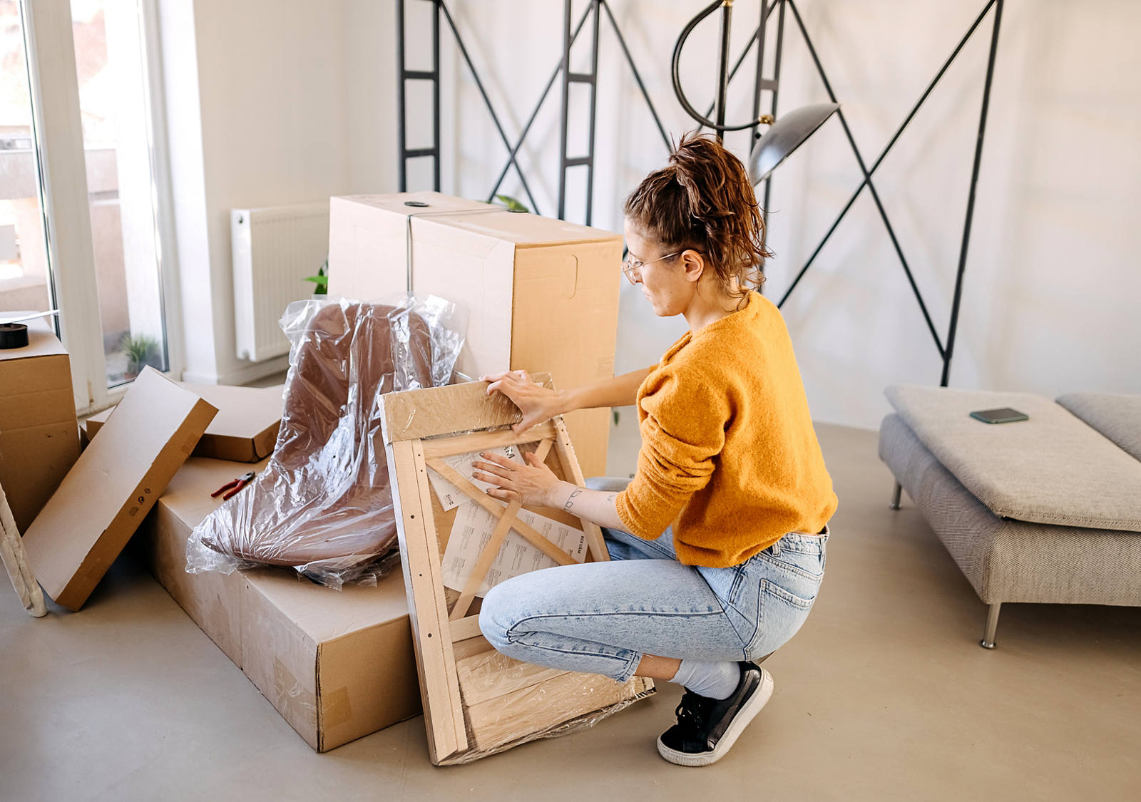 Woman packing furniture in apartment for moving.