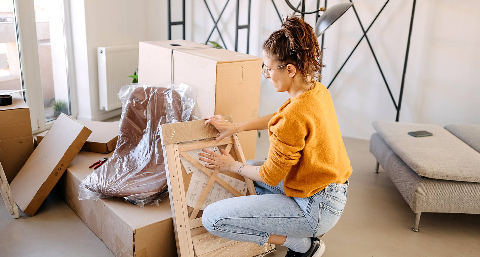 Woman packing furniture in apartment for moving.