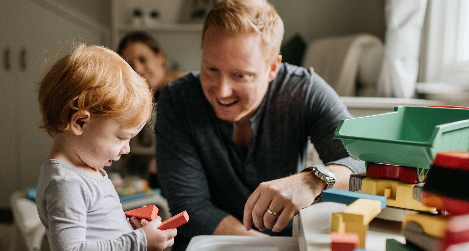 A l’intérieur, un père joue avec son enfant avec des blocs de construction.