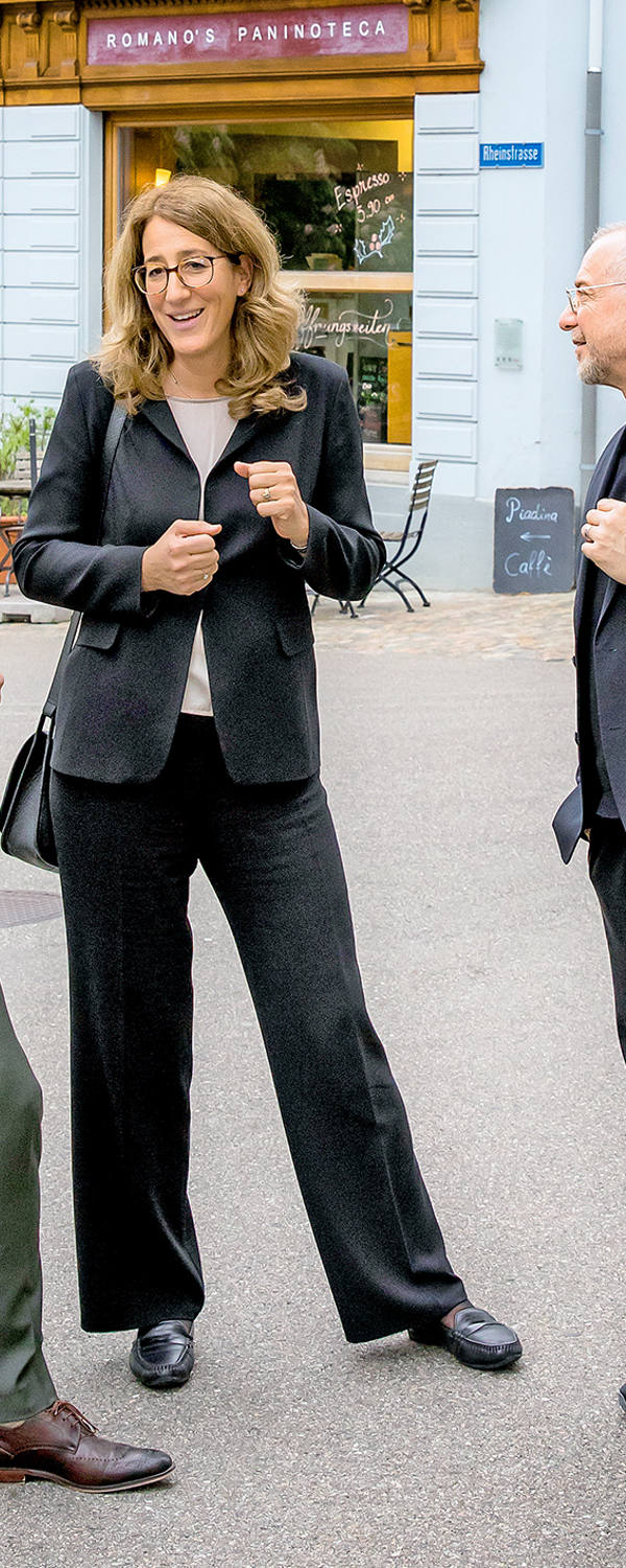 «im dialog» – Anne-Geneviève Bütikofer, Thomi Jourdan und Patrick Rohr stehen auf einem Platz in der Altstadt und unterhalten sich.